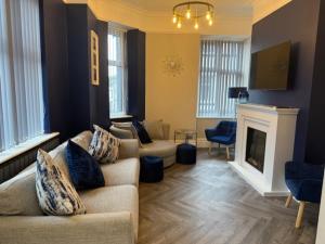 a living room with two couches and a fireplace at Stylish 4 bed in Central Conwy in Conwy