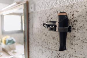 a blow dryer on a wall next to a mirror at Quinta da Avó Bella in Buarcos
