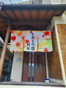 a banner on the front of a door with autumn leaves at もみじの宿別府 in Beppu