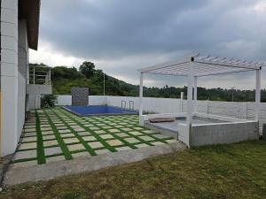 a backyard with a swimming pool and a pavilion at Rolling Hills in Nashik