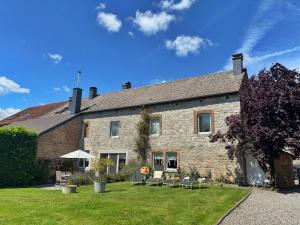 a large stone building with chairs in front of it at La Belly d'or in Izier +49 photos