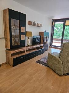 a living room with a television and a couch at Appartementresidenz am Kurpark Bad Salzuflen in Bad Salzuflen