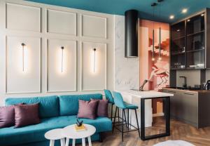 a living room with a blue couch and a kitchen at 8 - Il Becco Rosato - DonViore in Győr