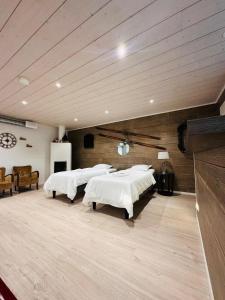 a room with four beds in a room with wooden ceilings at Alanko Lodge in Tornio