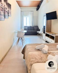 a bedroom with two beds and a living room at Apartamentos Basílica Santa Eulalia con Parking Gratis in Mérida