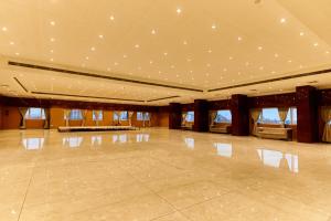 a large room with a dance floor with lights on the ceilings at Tania President Inn in Shirdi