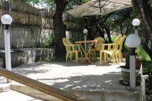 eine Terrasse mit einem Tisch und Stühlen unter einem Sonnenschirm in der Unterkunft Villa Gabliani in Mestia