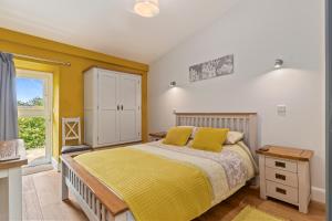 a bedroom with a bed and a window at Willow at Gorslwyd - Sound Retreat in Aberporth