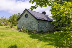 an old stone church in a field of grass at Willow at Gorslwyd - Sound Retreat in Aberporth