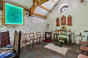 a room with a table and chairs and a fireplace at Willow at Gorslwyd - Sound Retreat in Aberporth