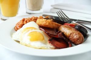 a plate of breakfast food with eggs bacon sausage and beans at Gortnaboul House in Kilgarvan