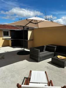 un patio con sombrilla y 2 sillas en Esprit Londonien - WIFI - TV -, en Bracquemont
