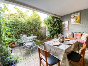 eine Terrasse mit einem Tisch und Stühlen sowie einem Tisch, einem Tisch und einem Stuhl in der Unterkunft Quince Cottage in Saint Michaels