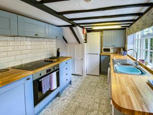 eine Küche mit blauen Schränken und einer Arbeitsplatte in der Unterkunft Quince Cottage in Saint Michaels + 11 Fotos