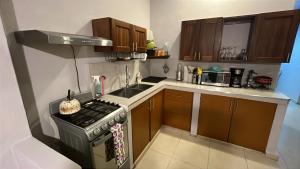 a small kitchen with a stove and a sink at Panoramic Paradise 5 min to downtown and beach in Zihuatanejo