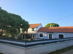 a white house with a fence in front of it at Holiday Home Nena in Drniš
