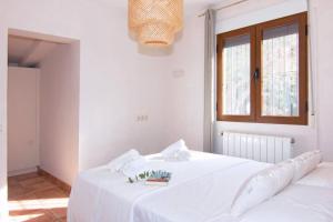 a white bed in a room with a window at Finca Les Oliveres in Benissa +26 photos
