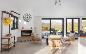 Una sala de estar con mesa y sillas y una chimenea. en Kourtaliotis Villa Crete, en Koxaré