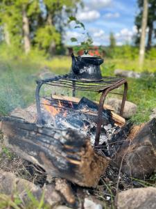 a fire with a tea pot on top of it at The Secret Cabin 