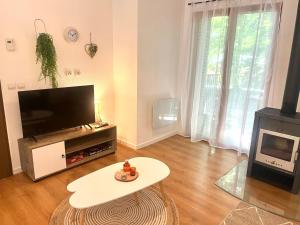 a living room with a flat screen tv and a table at Les Charmes - C09 in Eppe-Sauvage +1 photo