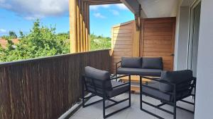 Un patio con dos sillas y una mesa en un balcón. en Euphrasie, en Lit-et-Mixe