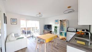 cocina y sala de estar con mesa y fregadero en Euphrasie, en Lit-et-Mixe