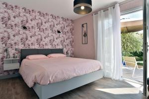 a bedroom with a bed and a pink wall at Maison du Bonheur - Parking - Wifi in Vains