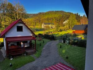 a small house with a red roof in a yard at Stolove Chatki Radków in Radków