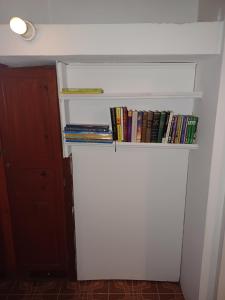 a book shelf with books on it next to a door at L'Anthurium-Location Saisonnière 4Etoiles in Le Tampon +6 photos