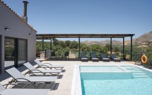 una piscina con tumbonas junto a una piscina en Kourtaliotis Villa Crete, en Koxaré