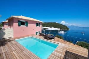 a house with a swimming pool and a view of the water at Villa Thalassa Desimi by Villa Plus in Katokhórion