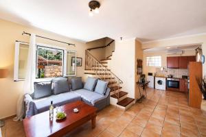 a living room with a blue couch and a kitchen at Villa Thalassa Desimi by Villa Plus in Katokhórion +33 photos