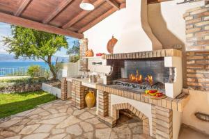 a patio with an outdoor kitchen with a fireplace at Villa Irida in Apraos