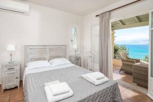 a bedroom with a bed and a balcony with the ocean at Villa Irida in Apraos +47 photos