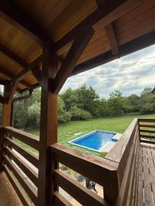 a wooden deck with a swimming pool in a yard at Vikendica Čardak in Srebrenik +13 photos