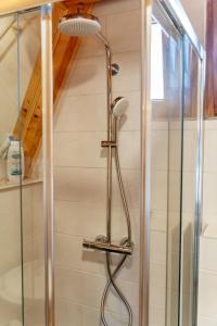 a shower with a shower head in a bathroom at WIND Cottage in Žabljak +29 photos