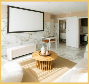 a living room with a large blank screen on the wall at B Unique Appartement Jacuzzi I Cinéma in Gaillard