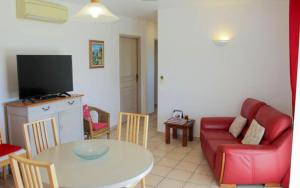 a living room with a red couch and a table at Le Petit Etang in Gréoux-les-Bains