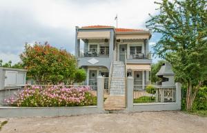 une maison avec une porte et des fleurs devant elle dans l'établissement SK Suites Thassos, à Skala Potamias