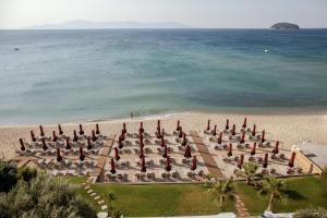 a group of umbrellas and chairs on a beach at Akti Hotel Kavala in Paleo Tsifliki
