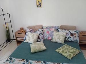 a couch with pillows on top of a green blanket at La Valentina si Gabriel in Vadu