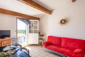a living room with a red couch and a tv at Bellevue De La Maréchale in Orgnac-lʼAven