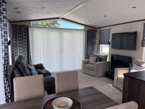 a living room with a couch and a tv at Drift Lodge in Tain
