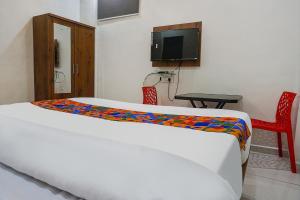 een slaapkamer met een bed en een tv in een kamer bij FabHotel Bliss Executive - shaniwar wada in Pune +24 foto's