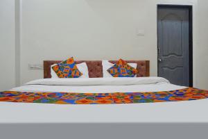 een bed met kleurrijke lakens en kussens erop bij FabHotel Bliss Executive - shaniwar wada in Pune