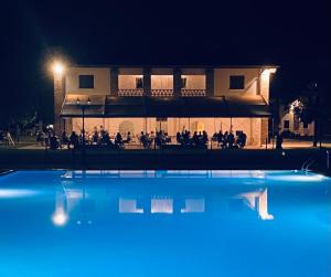 a building at night with a pool in front of it at Agriturismo con piscina immerso nella natura La Bisa in Trecenta