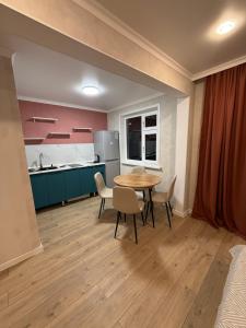 a kitchen with a table and chairs in a room at Квартира in Balqash