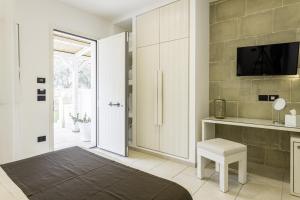 a bedroom with a door leading to a kitchen with a tv at Masseria Muntibianchi AgriResort Restaurant & SPA in Otranto