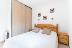 a bedroom with a white bed and a window at Terrasse avec vue sur les montagne pour 6 in La Joue du Loup