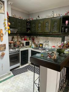 una cucina con mobili verdi e un piano di lavoro di Penthouse Jaccuzi Atlas Marrakech a Marrakech